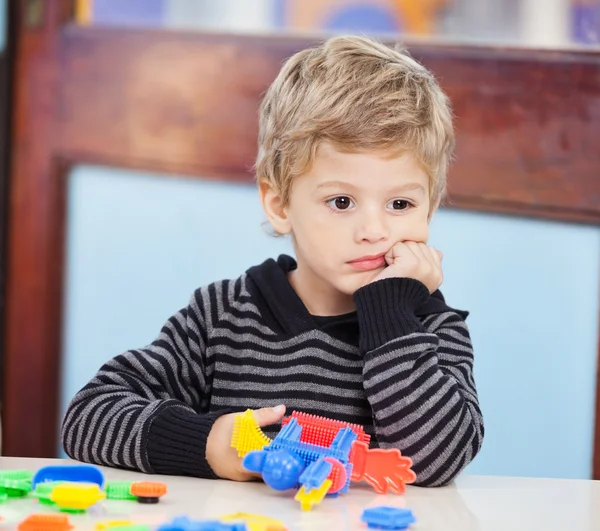 Junge mit Klötzen schaut in Vorschule weg — Stockfoto