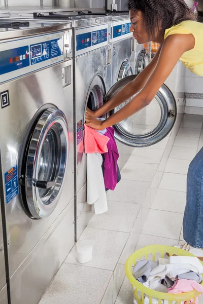 Mulher carregando máquina de lavar com roupas — Fotografia de Stock