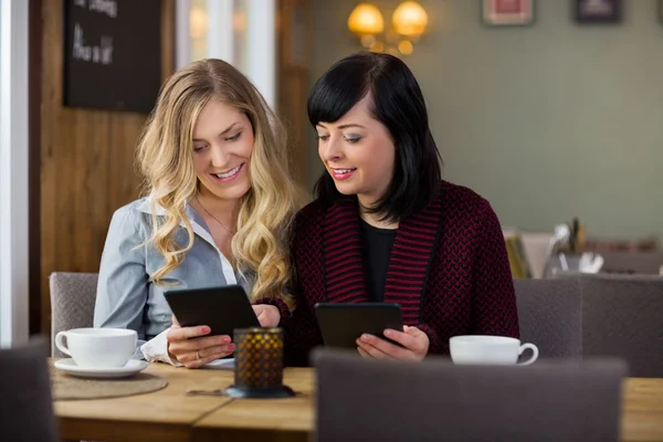 Vänner med digitala tabletter på coffeeshop — Stockfoto