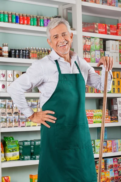Starszy mężczyzna właściciel stojąc przed półkami w sklepie — Zdjęcie stockowe