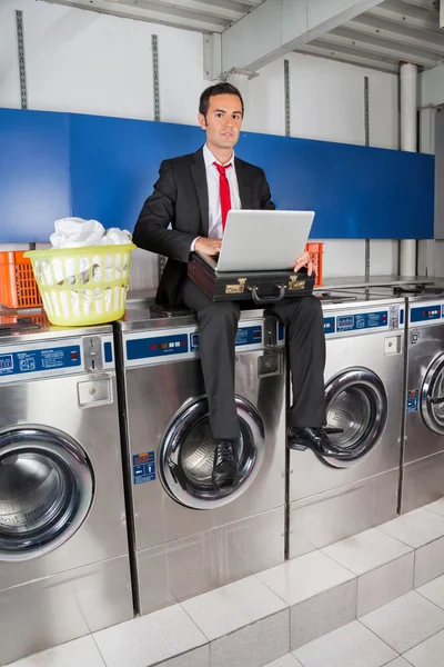 Businessman With Laptop In Laundry Stock Image