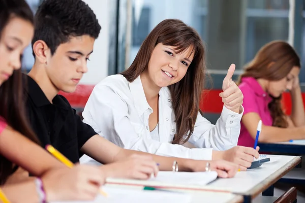 Vertrouwen tienermeisje gebaren duimen omhoog in klas — Stockfoto