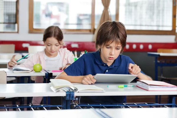 Schooljongen met behulp van digitale tablet in klas — Stockfoto