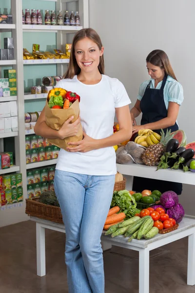Vrouw die kruidenier zak in supermarkt — Stockfoto