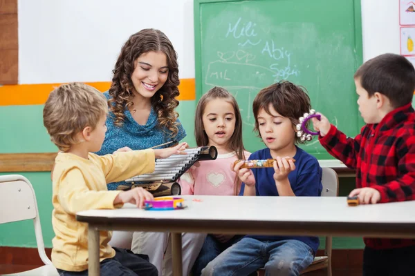 Kinder und Lehrer spielen mit Musikinstrumenten — Stockfoto