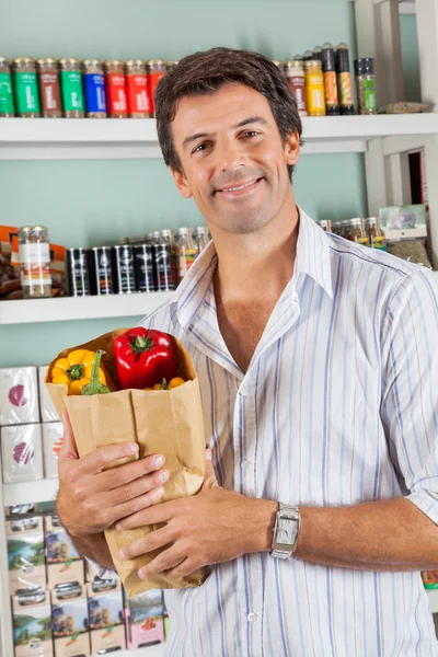 Hombre con bolsa de comestibles en el supermercado —  Fotos de Stock