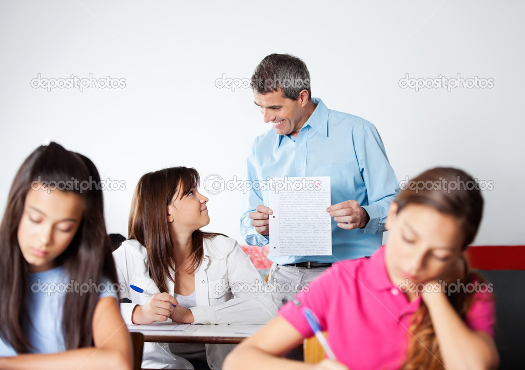 Male Professor Showing Paper To Student During Examination