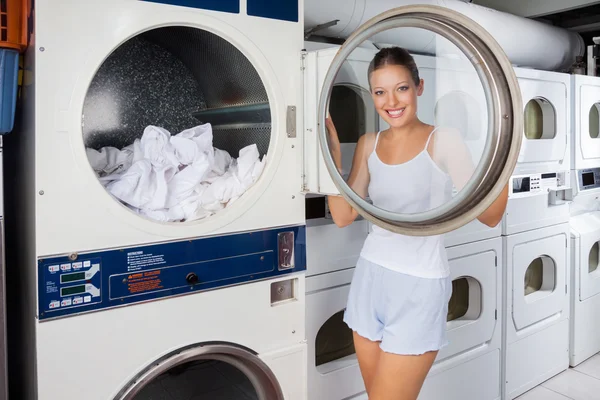 Donna guardando attraverso lavatrice coperchio — Foto Stock