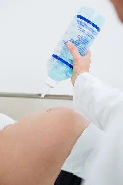 Ginecologista aplicando gel de ultra-som na barriga da mulher grávida — Fotografia de Stock