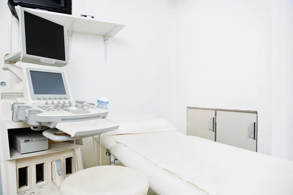 Клиника с ультразвуковой машиной и кроватью — стоковое фото