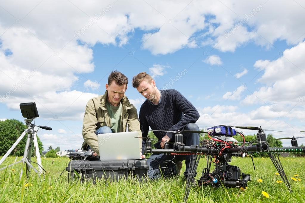 Technicians Working On Laptop By UAV in Park