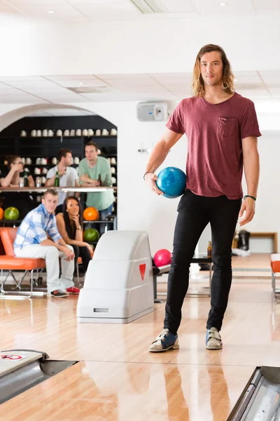 Jeune homme avec boule de bowling en club — Photo