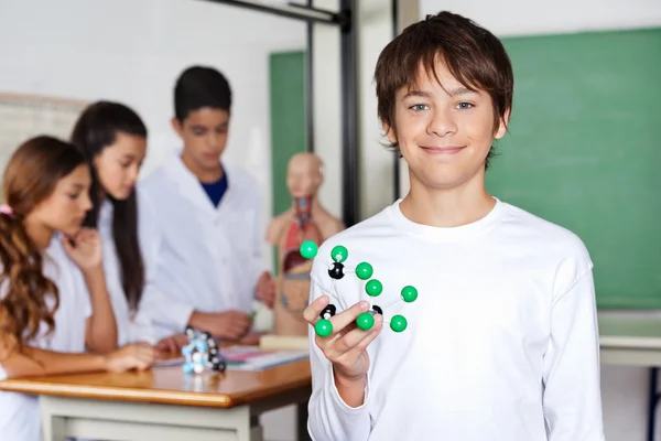 Teenage Schoolboy Holding Molecular Structure in Biology Class — стоковое фото