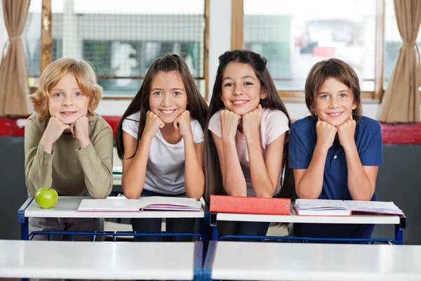 Crianças em idade escolar Inclinadas na mesa Juntas — Fotografia de Stock