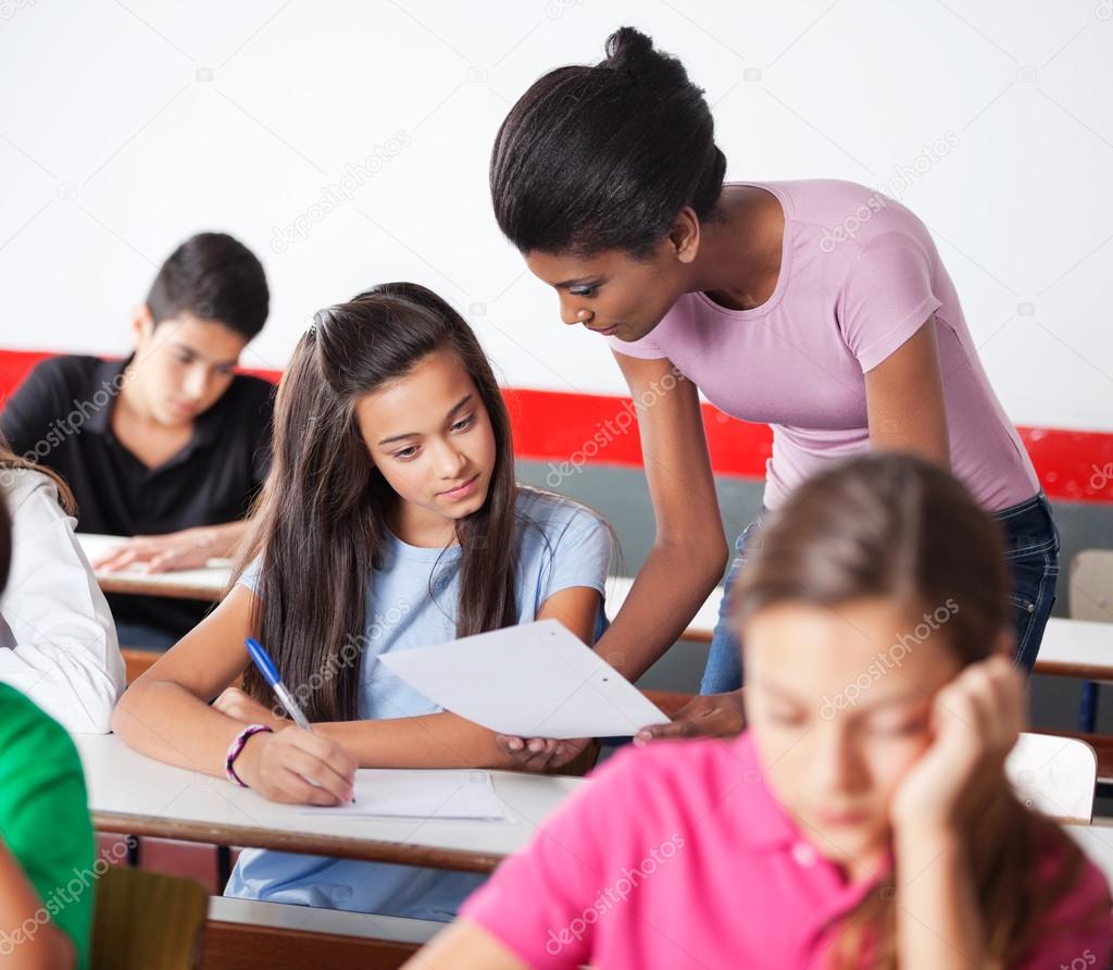 Teacher Showing Paper To Teenage Girl During Examination