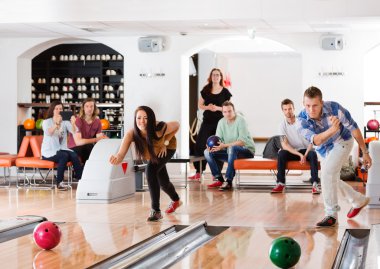 bowling salonu içinde oynayan genç arkadaşlar