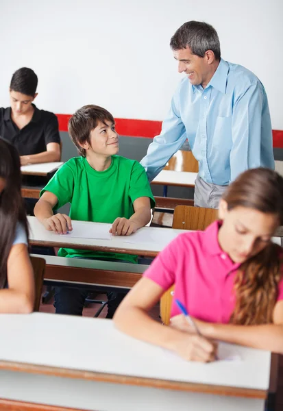 Lehrer und Teenager schauen sich während der Prüfung an — Stockfoto