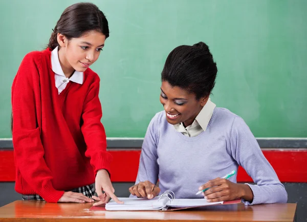 Schoolgirl Asking Question To Female Teacher At Desk — Stock Photo, Image