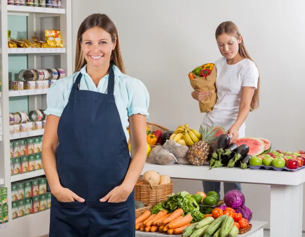 Elárusítónő női ügyfél vásárlás a szupermarketben — Stock Fotó