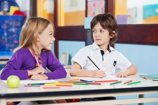 Boy Looking At Female Friend While Drawing In Classroom — Stock Photo, Image