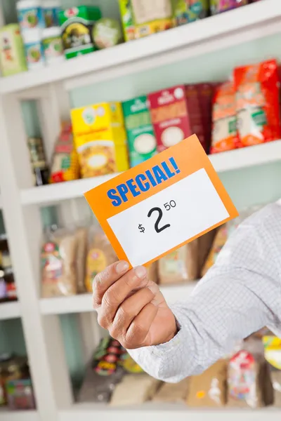 Männlicher Besitzer hält Rabattschild im Supermarkt — Stockfoto