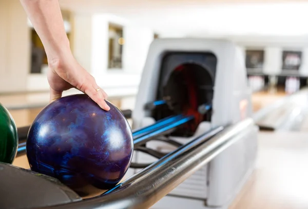 Ręka mężczyzny podnoszenia Bowling Ball z Rack — Zdjęcie stockowe