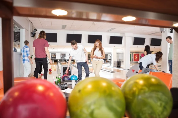 Personnes Bowling avec des boules au premier plan — Photo