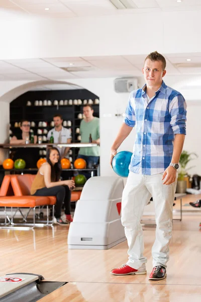 Junger Mann hält Bowlingball in Verein — Stockfoto