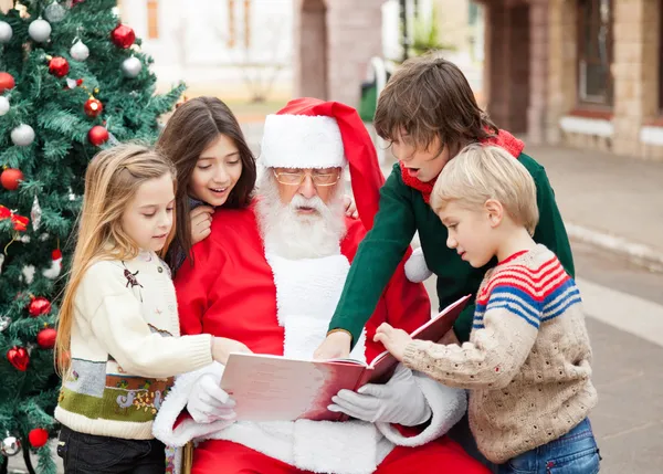 Barn och jultomten läsa bok — Stockfoto