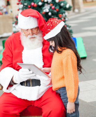meisje en santa claus met behulp van digitale Tablet PC