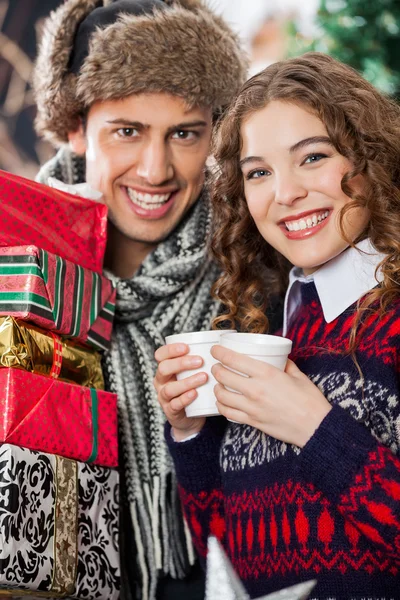 Par med engångsmuggar och julklappar — Stockfoto