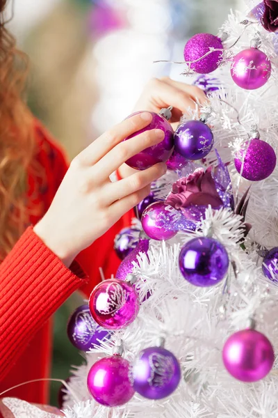 Besitzer hängt Kugeln an Weihnachtsbaum — Stockfoto