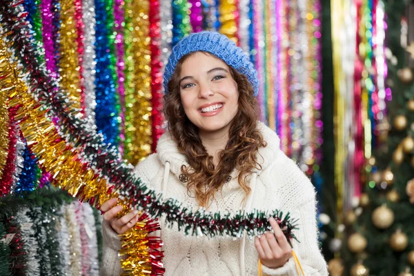 Młoda kobieta wybiera tinsels w sklepie — Zdjęcie stockowe