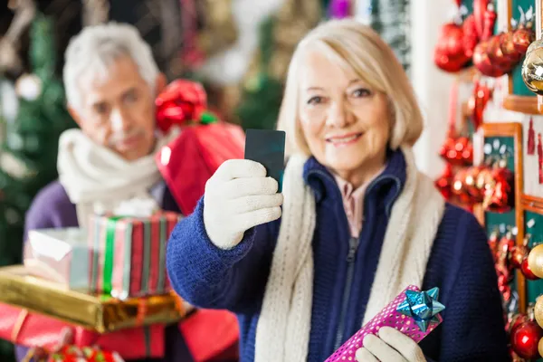 Donna in possesso di carta di credito al negozio di Natale — Foto Stock