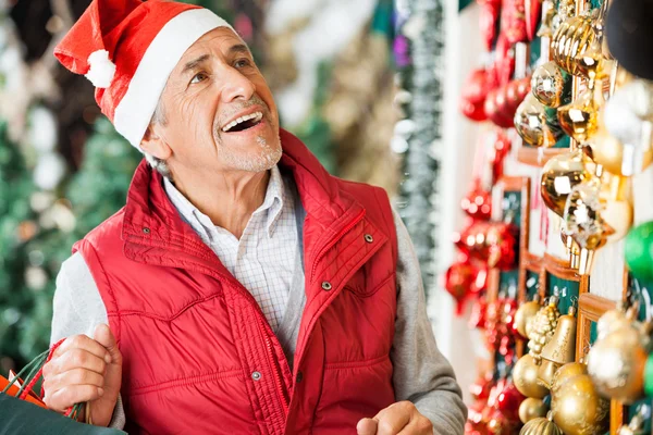 Άνθρωπος επιλογή χριστουγεννιάτικα στολίδια στο κατάστημα — Φωτογραφία Αρχείου