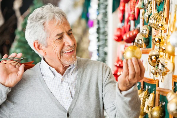 Man kerstballen bij store kopen — Stockfoto