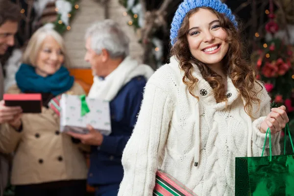 Glückliche Frau mit Familie im Weihnachtsgeschäft — Stockfoto