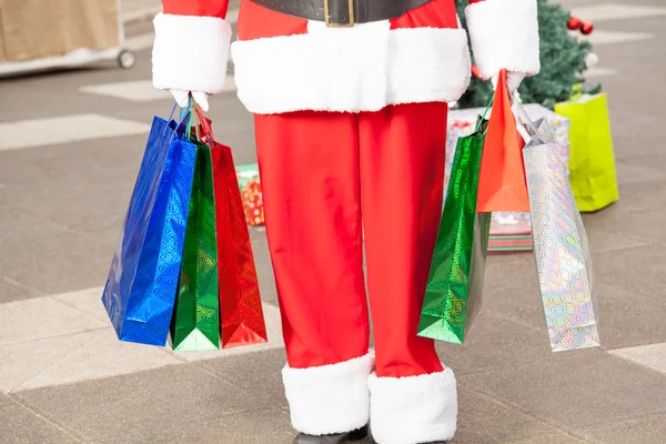 Santa claus uitvoering shopping tassen — Stockfoto