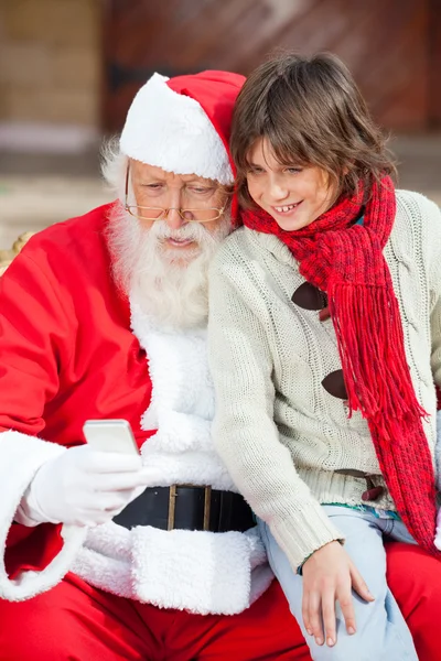 Santa claus en jongen gebruikend smartphone — Stockfoto