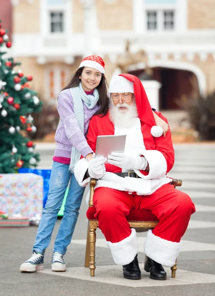 Chica con Santa Claus usando tableta digital —  Fotos de Stock