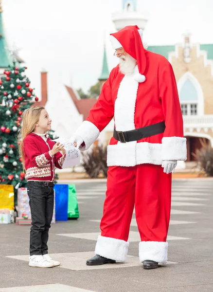 Ragazza che dà la lista dei desideri a Babbo Natale — Foto Stock