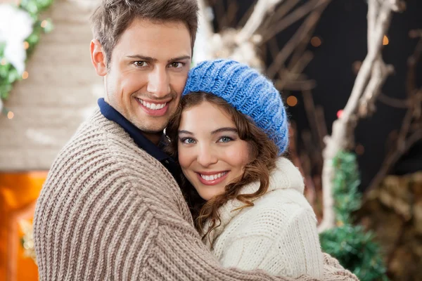 Casal feliz abraçando na loja de Natal — Fotografia de Stock