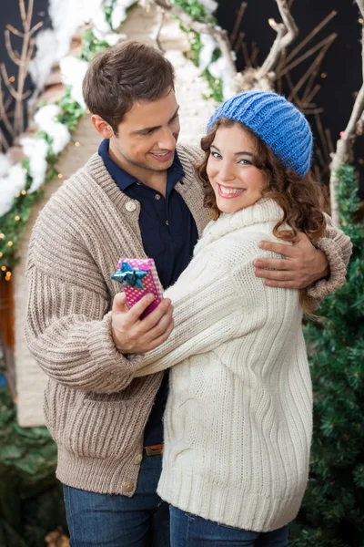 Paar umarmt sich im Weihnachtsgeschäft — Stockfoto