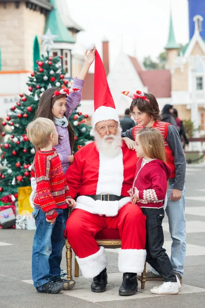 Children Playing With Santa Claus's Hat Royalty Free Stock Photos