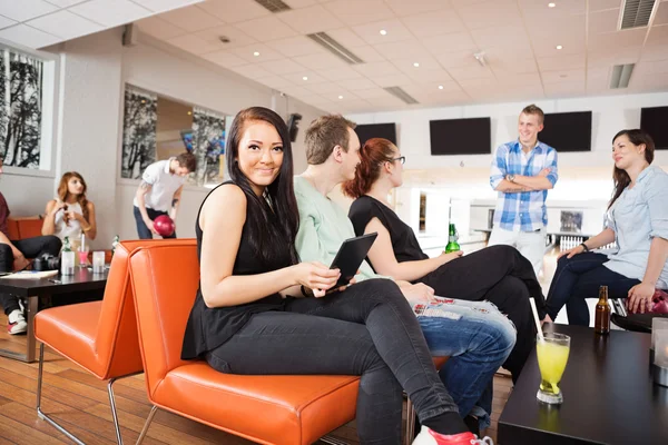 Donna con tavoletta digitale mentre bowling — Foto Stock