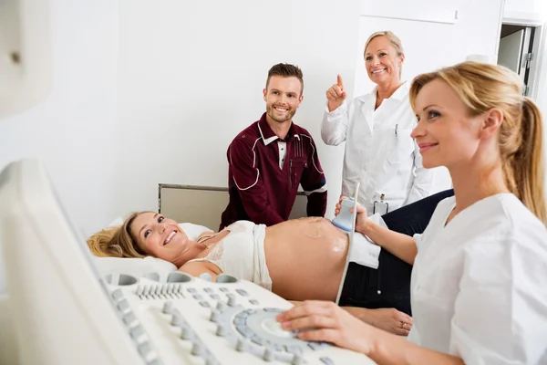 Casal e médicos olhando para ultra-som — Fotografia de Stock