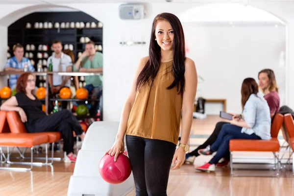 Szczęśliwa młoda kobieta posiadania piłki bowling w klubie — Zdjęcie stockowe