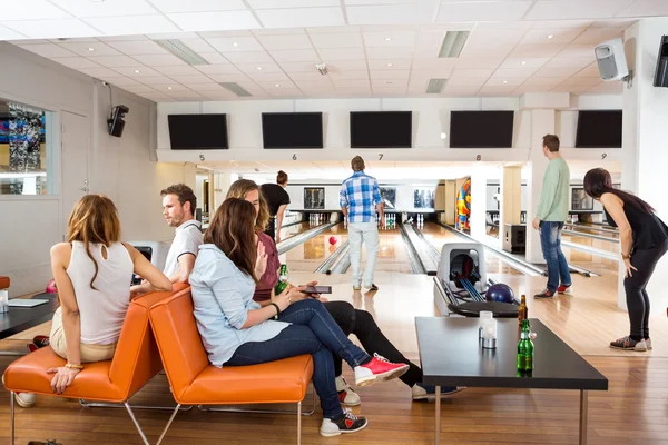 Vänner tillbringar fritid i bowling club — Stockfoto