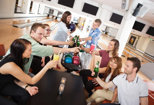 Vrienden dranken in bowlingclub roosteren — Stockfoto