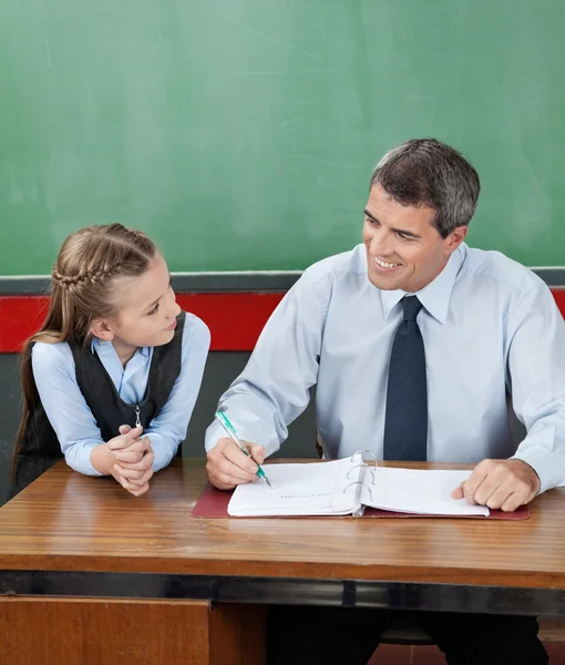 Professore e bambina che si guardano alla scrivania — Foto Stock